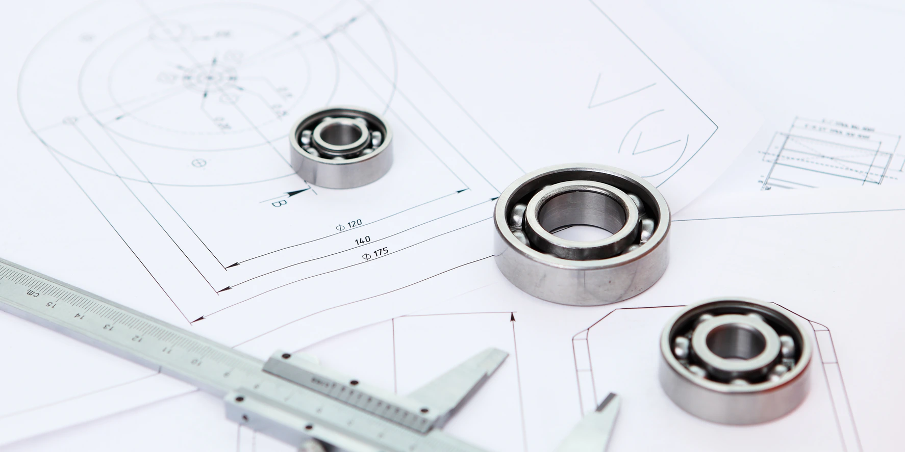 Precision bearings and measuring caliper on technical drawings for CNC engineering support