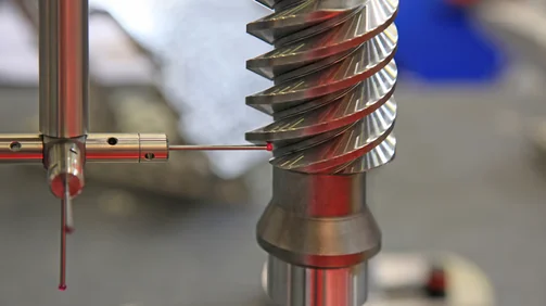 CMM probe inspecting a precision machined metal component for CNC quality control